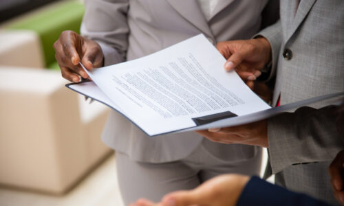 diverse-business-partners-reading-contract-together